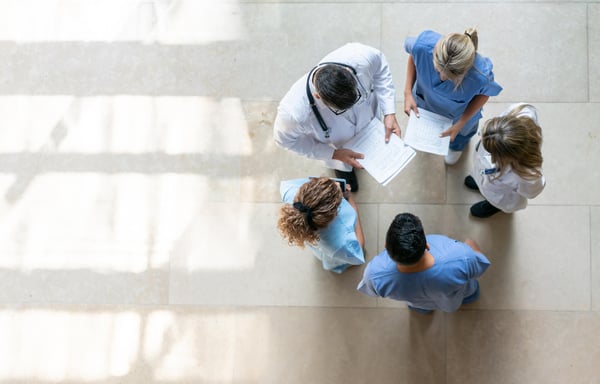 Healthcare staff standing in a ring, seen from above