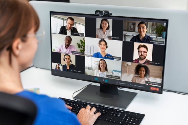 Kvinna har videosamtal på datorn med många deltagare