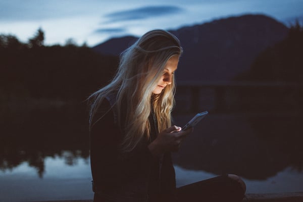 Young blond female looking at mobile screen