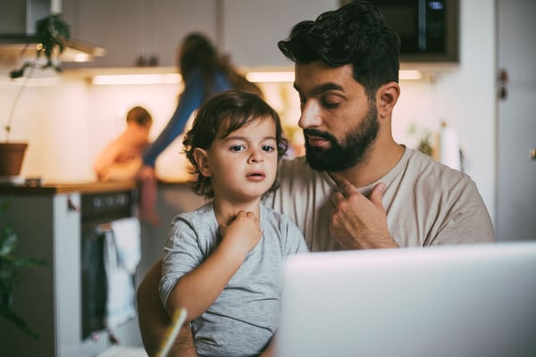 Pappa och barn framför laptop