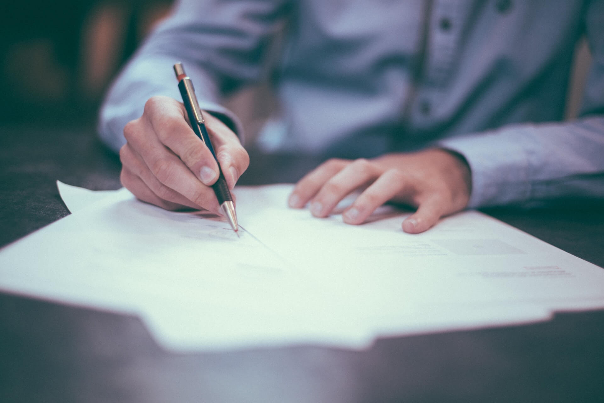 Man holding pen signing contract